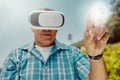 Senior mixed race farmer using virtual reality headset to choose and select option with cgi. Hispanic elderly man