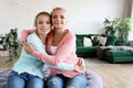 Senior mom and her adult daughter are hugging, looking at camera and smiling. At Home. Royalty Free Stock Photo