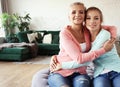 Senior mom and her adult daughter are hugging, looking at camera and smiling. At Home. Royalty Free Stock Photo