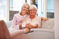 Senior Mother With Adult Daughter Relaxing On Sofa