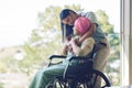 Senior mother, woman and hug with wheelchair, love and care with bonding, kindness and nursing home. Girl, embrace and