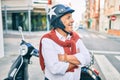 Senior motorcyclist man smiling happy wearing moto helmet at the city