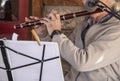 Senior musician -older man plays a flute -closeup with music on stand and microphone Royalty Free Stock Photo