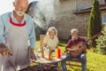 Senior neighbors having a backyard barbecue party