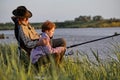 Senior nice man and little boy together at the pond. Little boy with fishing rod Royalty Free Stock Photo