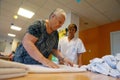 Senior and nurse at the laundry daily works on a nursing home in Mallorca wide view