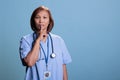 Senior nurse showing shhh taboo sign with finger to lips while working at medical expertise