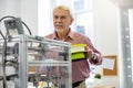 Senior office worker being about to insert filament into printer