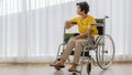 A senior old Asian woman sitting in wheelchair and with lonely feeling and waiting for someone to visit and take care of her with Royalty Free Stock Photo