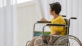 A senior old Asian woman sitting in wheelchair and with lonely feeling and waiting for someone to visit and take care of her with Royalty Free Stock Photo