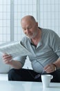 Senior old man reading newspaper at home Royalty Free Stock Photo