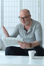 Senior old man reading newspaper at home Royalty Free Stock Photo