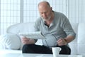 Senior old man reading newspaper at home Royalty Free Stock Photo