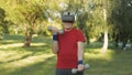 Senior old grandfather man in VR headset helmet making fitness exercises with dumbbells outdoors Royalty Free Stock Photo