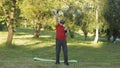 Senior old grandfather man in VR headset helmet making fitness exercises with dumbbells in park Royalty Free Stock Photo