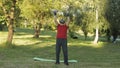 Senior old grandfather man in VR headset helmet making fitness exercises with dumbbells in park Royalty Free Stock Photo