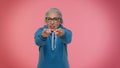 Senior old granny woman pointing around with finger gun gesture, shooting killing with hand pistol Royalty Free Stock Photo