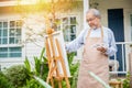 Senior old man painting picture artwork using brush and water color on canvas