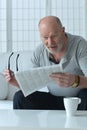 Senior old man reading newspaper at home Royalty Free Stock Photo