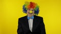 Senior old woman clown in colorful wig smiling, making silly faces, fool around Royalty Free Stock Photo