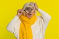 Senior old woman holds magnifying glass near face looking at camera with big zoomed eye, analyzing Royalty Free Stock Photo