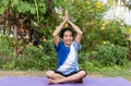 Senior old woman warming stretching exercising on yoga mat outdoors on nature green background Royalty Free Stock Photo