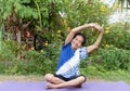 Senior old woman warming stretching exercising on yoga mat outdoors on nature green background Royalty Free Stock Photo