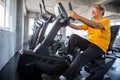 Senior older man exercising on cycling machine relaxing in fitness gym. aged . Old male workout .Mature sport training. Royalty Free Stock Photo