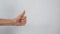 Senior or older woman`s hand doing thumbs up sign on white background