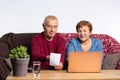 Senior online concept and pandemic. Spouses pay for services online at home while sits on the couch