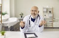 Senior online doctor sitting at desk and giving telemedicine consultation via video call