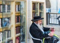 A senior Othodox jewish man siting and drinking juice at Western Wall, Wailing Wall, an ancient limestone wall in the Old City of