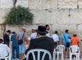 A senior Othodox jewish man siting at Western Wall, Wailing Wall, an ancient limestone wall in the Old City of Jerusalem, part of
