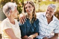 Senior parents in nature with their adult daughter sitting, talking and bonding together in a garden. Happy, love and Royalty Free Stock Photo