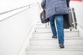 passenger carries his heavy suitcase and hand luggage up the stairs to the cabin of the airplane Royalty Free Stock Photo