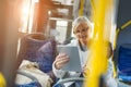 Senior woman using tablet, while riding public bus Royalty Free Stock Photo