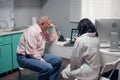 Senior patient looking attentively at his x-ray on the screen of the doctors laptop Royalty Free Stock Photo