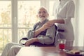 Senior patient in nursing home with helpful nurse in white uniform Royalty Free Stock Photo