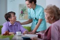 Senior patient of nursing home and helpful young nurse