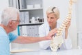 Senior patient showing spine problems to doctor at table Royalty Free Stock Photo