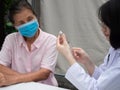 Senior patient  vacination in a inflatble hospital, doctor prepare vaccine and syrign for a woman Royalty Free Stock Photo