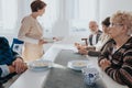 Senior patients and nurse in local nursing home during dinner time Royalty Free Stock Photo