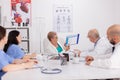 Senior pediatrician woman discussing sickness treatment using clipboard for medical presentation