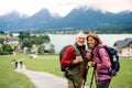 Senior pensioner couple with nordic walking poles hiking in nature.