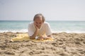 Senior pensioner sitting relaxed on the beach - retired old man on his 70s looking at the sea thoughtful and contemplative with