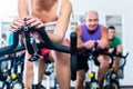 Senior people in gym spinning on fitness bike Royalty Free Stock Photo