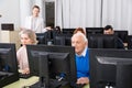 Senior people learning to use computers with young tutor Royalty Free Stock Photo