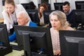 Senior people learning to use computers with young tutor Royalty Free Stock Photo
