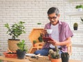 Senior people lifestyle and small business concept.Active  Asian elderly man sitting at table with houseplants and gardening tools Royalty Free Stock Photo