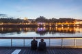 Senior people, and old couple of lovers, sitting on the quays of the riverbank of the rhone admiring the river during a summer Royalty Free Stock Photo